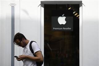 A man looks at his phone as he walks past an authorised apple reseller store in Galway A man looks at his phone as he walks past an authorised apple reseller store in Galway