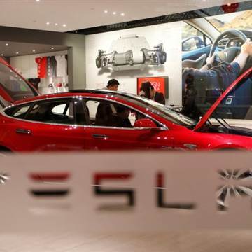 A man looks around Tesla Motors' Model S P85 at its showroom in Beijing
