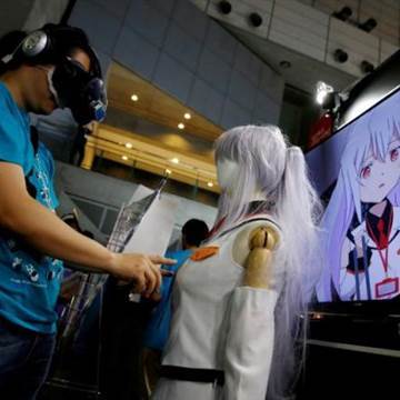 Image: A man touches a mannequin as he tries out a M2 Co.Ltd's "E-mote" system