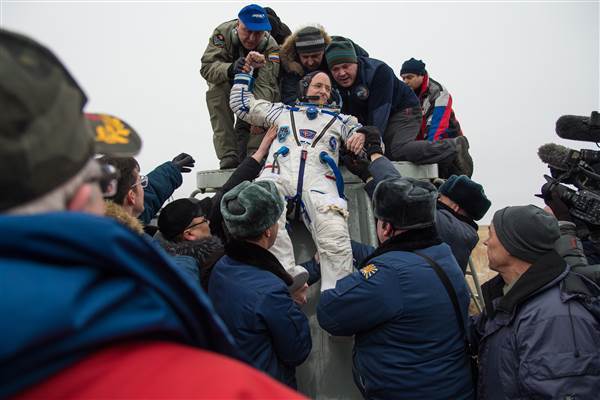 Image: Expedition 46 Commander Scott Kelly of NASA is helped out of the Soyuz TMA-18M spacecraft Image: Expedition 46 Commander Scott Kelly of NASA is helped out of the Soyuz TMA-18M spacecraft