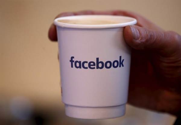 A journalist holds a cups with the Facebook logo at the new Facebook Innovation Hub during a preview media tour in Berlin A journalist holds a cups with the Facebook logo at the new Facebook Innovation Hub during a preview media tour in Berlin
