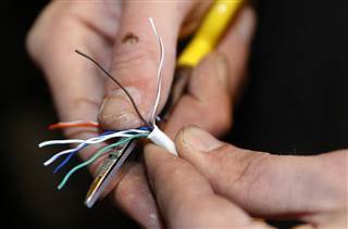 A technician strips back covering from a ethernet cable at a residential home as part of Google Fiber services in Provo A technician strips back covering from a ethernet cable at a residential home as part of Google Fiber services in Provo