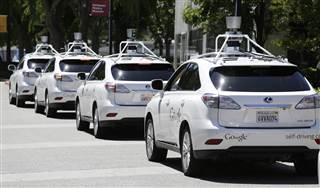 Image: Image: A row of Google self-driving cars are shown outside the Computer History Museum in Mountain View, Calif.
