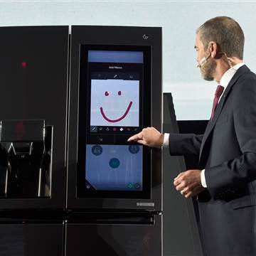 Image: An LG employee  demonstrates the LG Smart InstaView Door-in-Door refrigerato