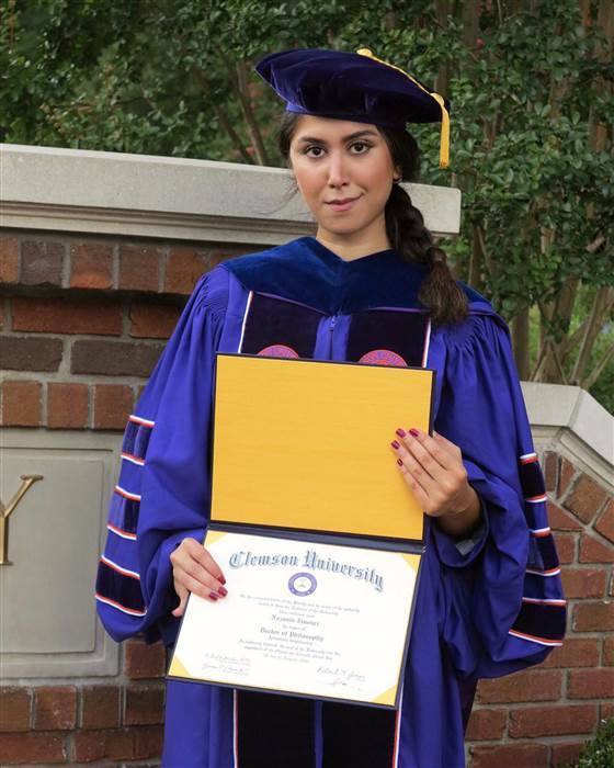 Image: Nazanin Zinouri poses for a photo with her PhD degree from Clemson University in Clemson, South Carolina. Image: Nazanin Zinouri poses for a photo with her PhD degree from Clemson University in Clemson, South Carolina.