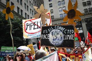 Image: Climate change activists carry signs as they march during a protest in downtown in Philadelphia a day before the start of the Democratic National Convention on July 24, 2016. Image: Climate change activists carry signs as they march during a protest in downtown in Philadelphia a day before the start of the Democratic National Convention on July 24, 2016.