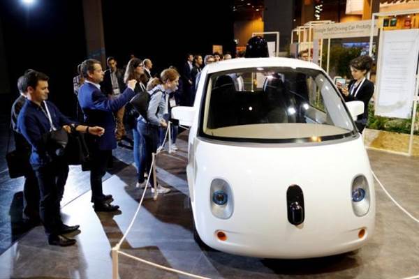 Visitors look at a self-driving car by Google displayed at the Viva Technology event in Paris Visitors look at a self-driving car by Google displayed at the Viva Technology event in Paris